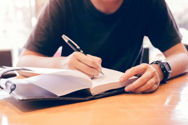 close-up-of-young-hand-writing-notes-in-study-room-.jpg